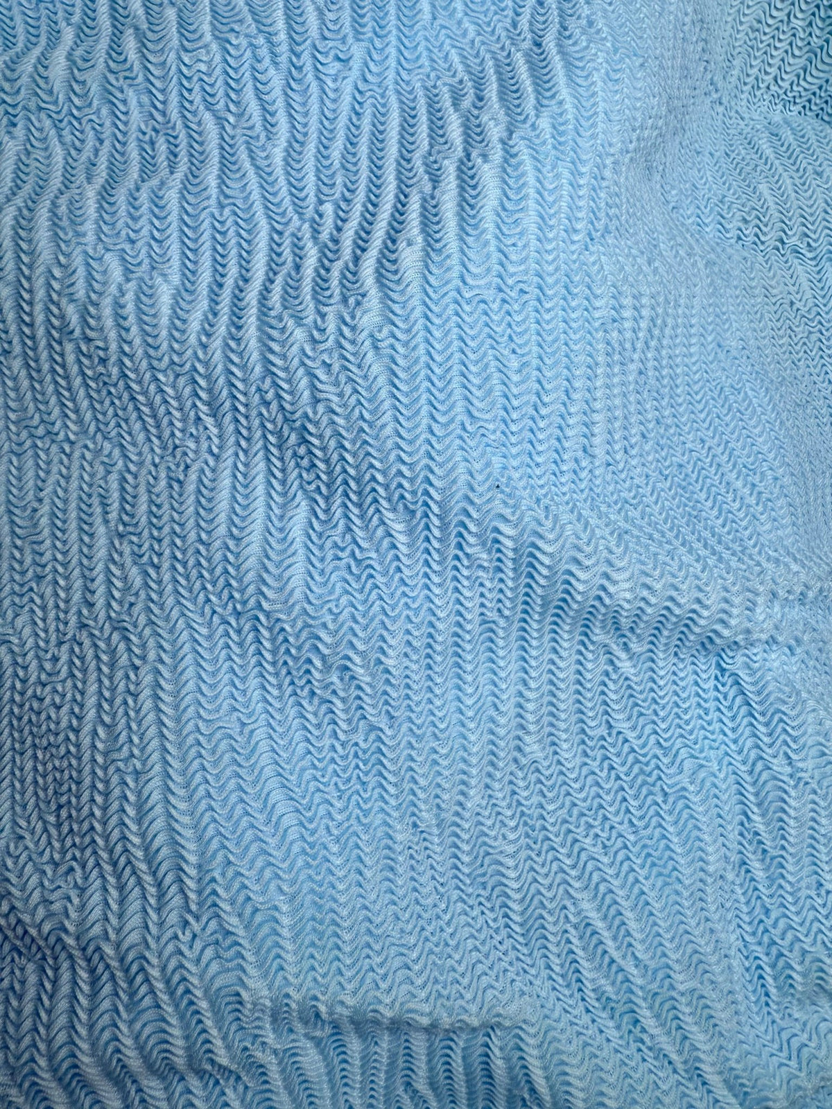 Light blue ruched swimwear fabric with textured, wavy pattern detail