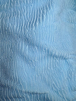 Light blue ruched swimwear fabric with textured, wavy pattern detail