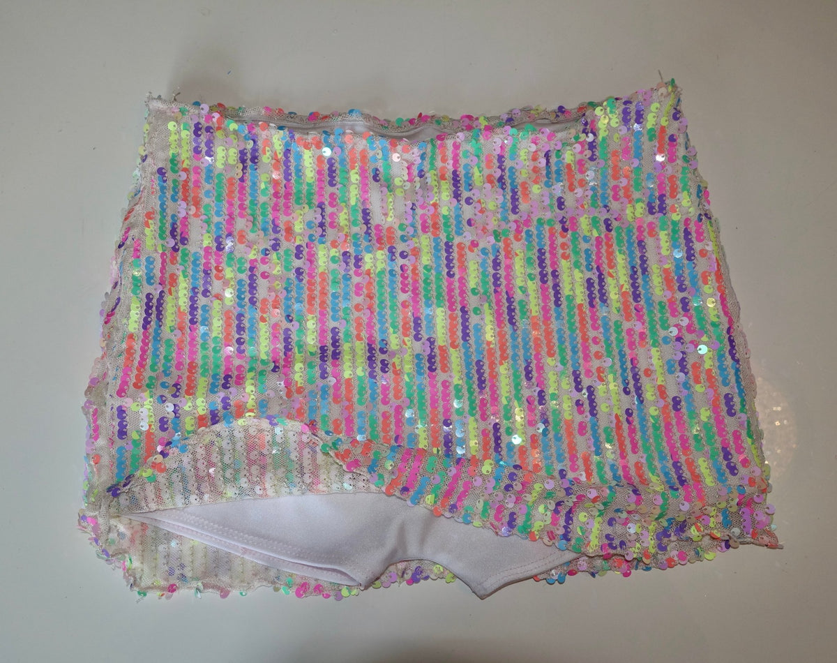 Handmade bikini bottom with colorful sequin stripes on white fabric, laid flat