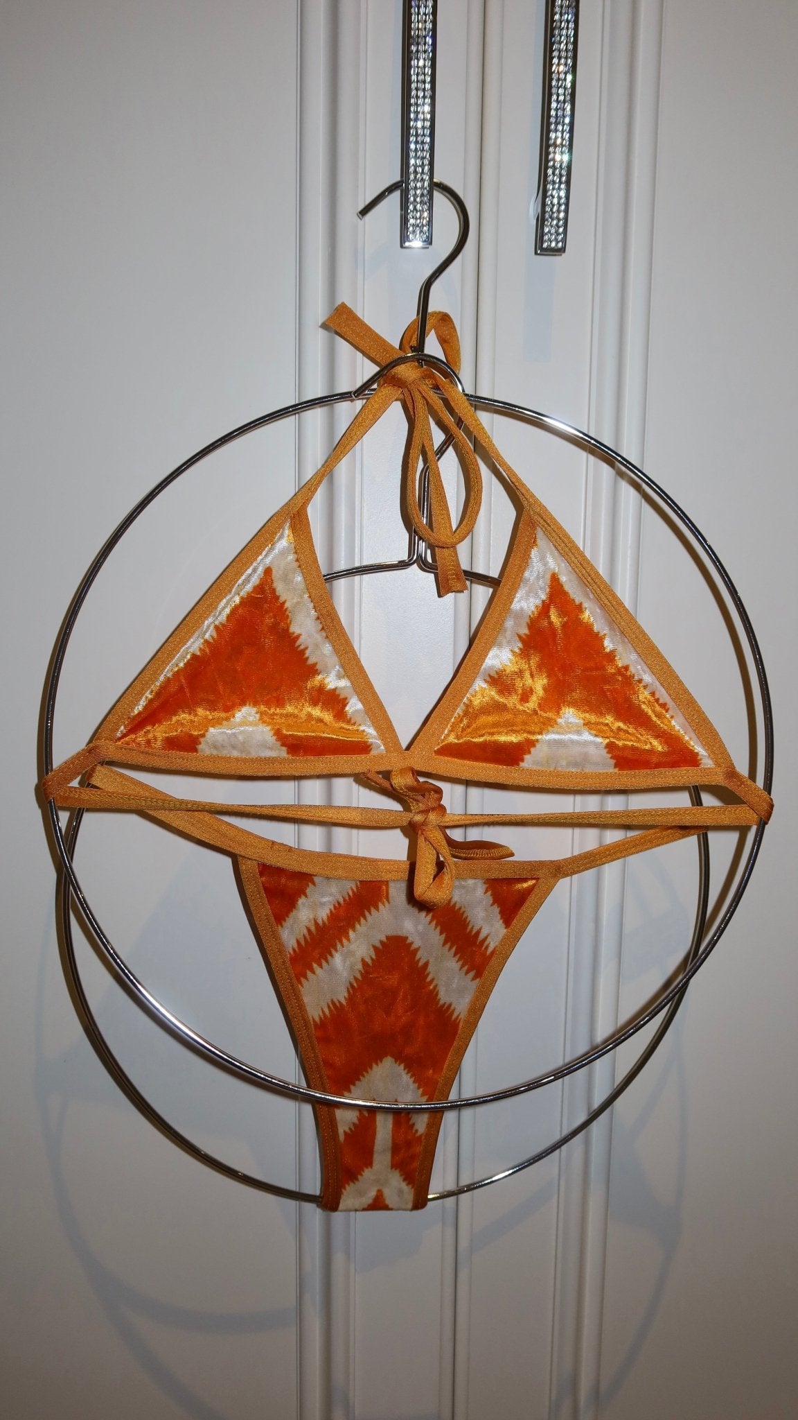 Orange and white handmade reversible bikini set with chevron pattern on hanger