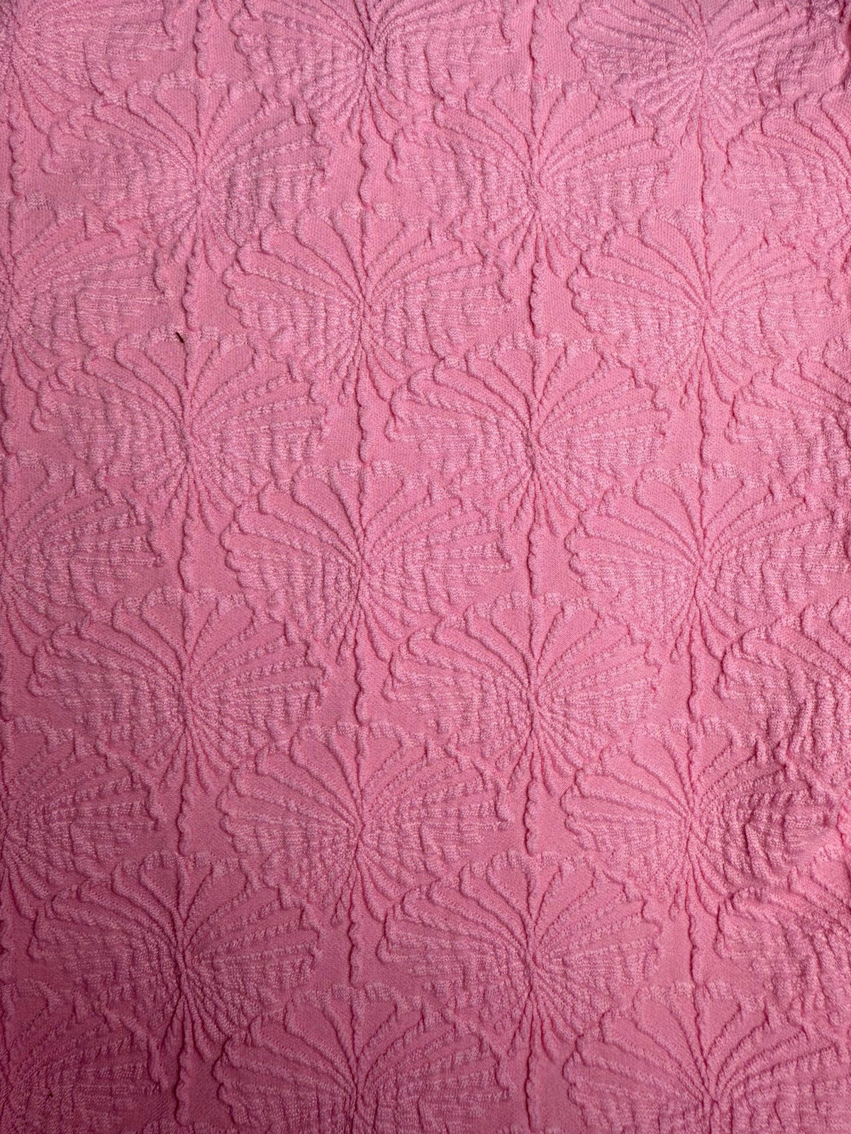 Pink textured fabric with embossed floral pattern, ideal for handmade swimwear, close-up view
