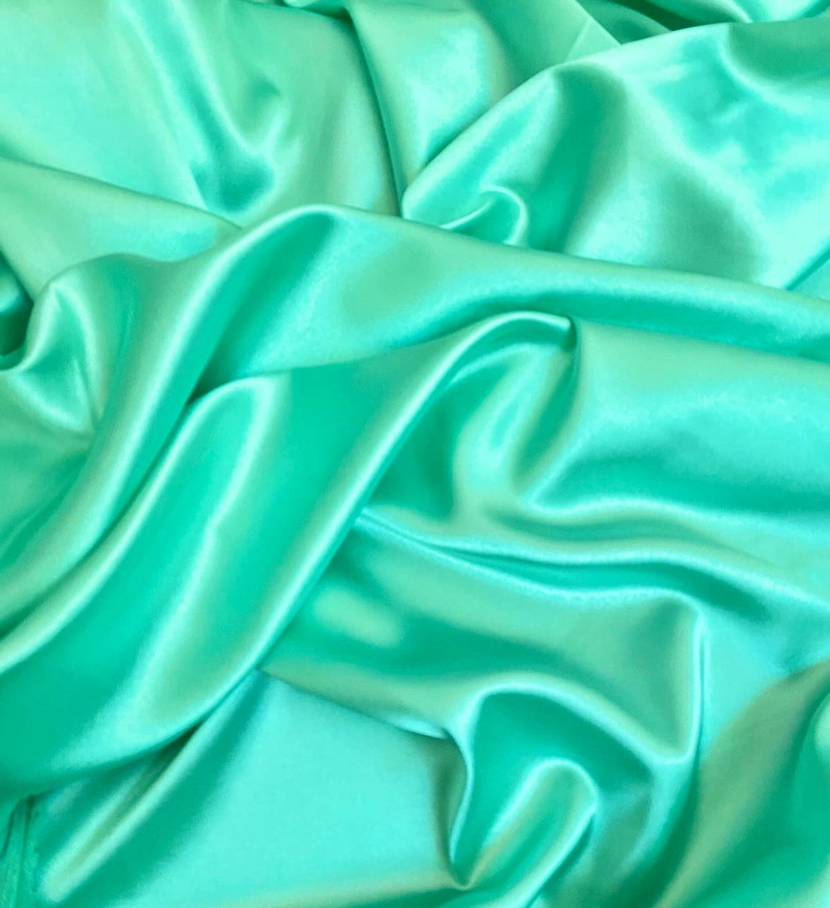 Aqua green silky swimwear fabric with a smooth, shiny and soft texture, ideal for bikinis.