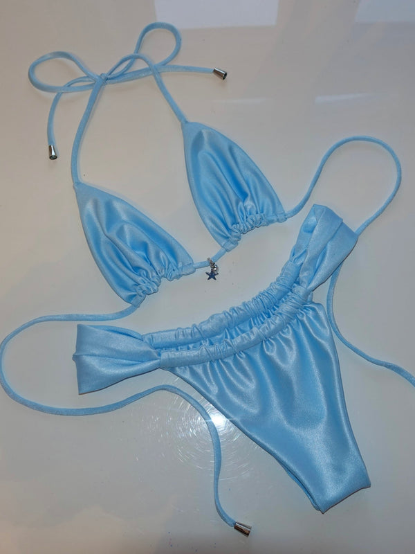 Light blue handmade reversible bikini with string ties and starfish charm on white background