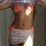 Woman wearing a handmade peach bikini top and sequin mini skirt with beaded side ties