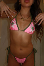 Woman wearing handmade pink and green floral beaded bikini set