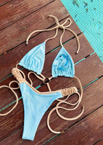 Light blue handmade bikini with beige straps and seahorse beaded detail by a pool