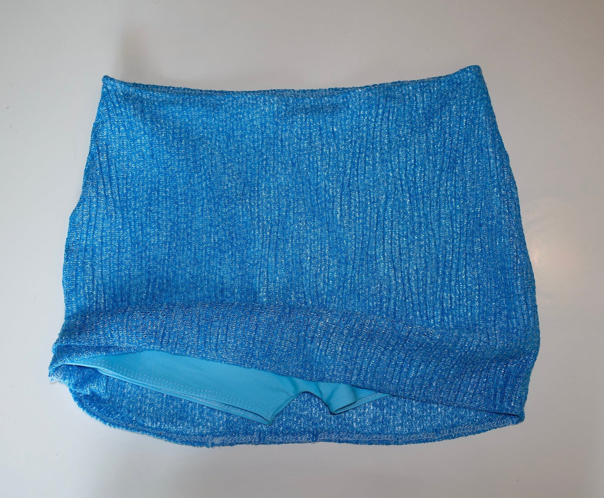 Blue textured swimwear skirt with ribbed fabric, laid flat on a white background